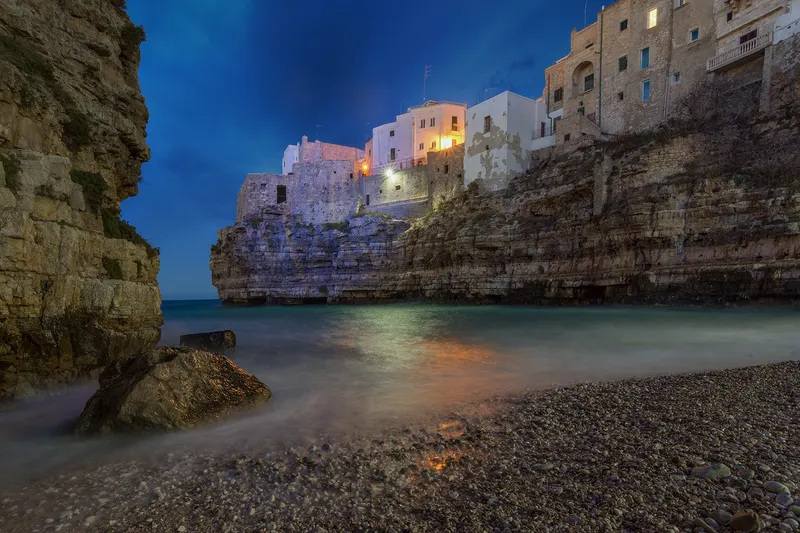 Lama Monachile e le case sulla scogliera di Polignano a Mare all'ora blu